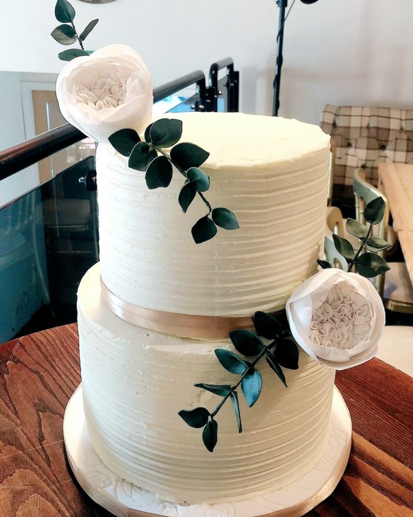 2 tier rustic buttercream cake with sugar roses and leaves